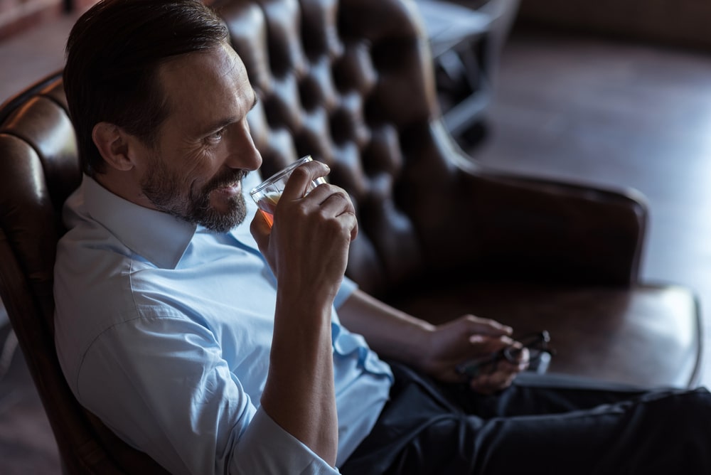 A man enjoys a drink.